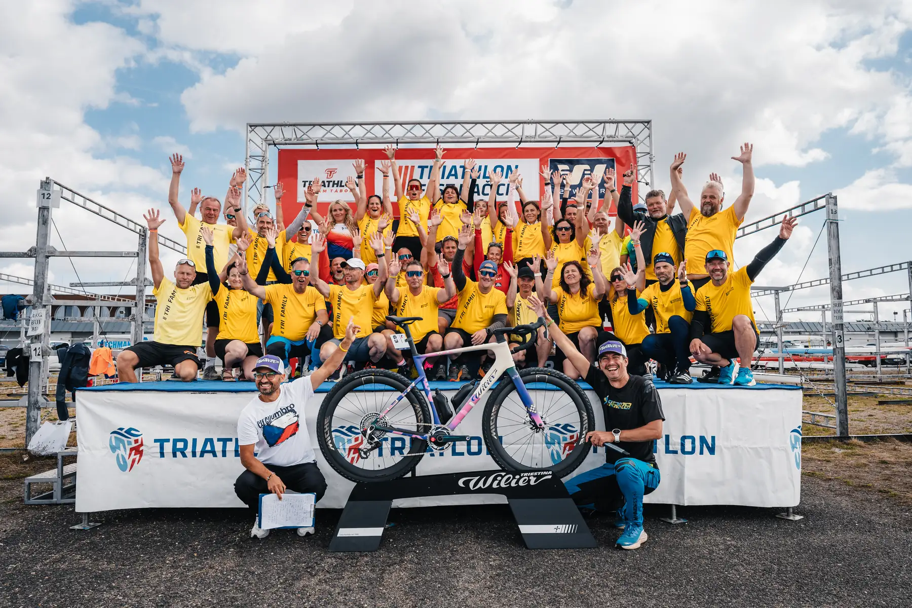 Pořadatelé v tričkách TRI FAMILY na pódiu po skončení Triathlon Fest Račice