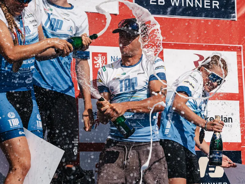 Vítězové stříkají šampaňské na stupních vítězů Triathlon Fest Račice